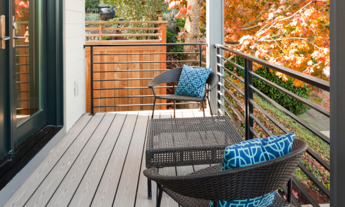 An outdoor deck with wooden boards and black railings.  
