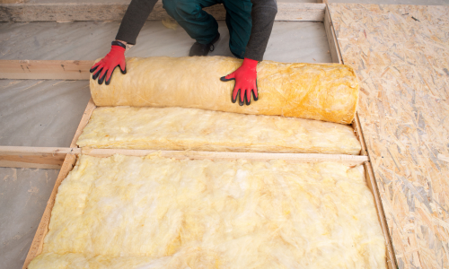 Yellow insulation being installed to a floor.