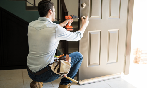 A contractor installing a door lock.